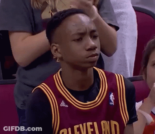 A Young Man In A Cleveland Jersey Is Sitting In The Stands . GIF