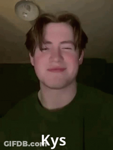 A Young Man In A Green Shirt Is Smiling With His Eyes Closed And The Word Kys Written On His Face . GIF