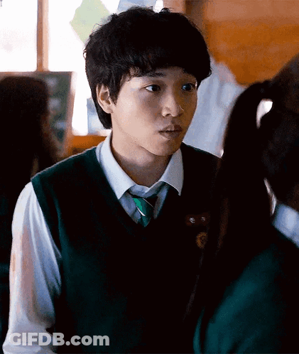 A Young Man In A Green Vest And Tie Is Looking At A Girl GIF