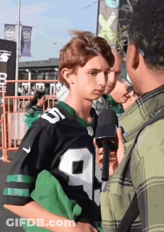 A Young Man In A Jets Jersey Is Being Interviewed By A Man Holding A Microphone GIF