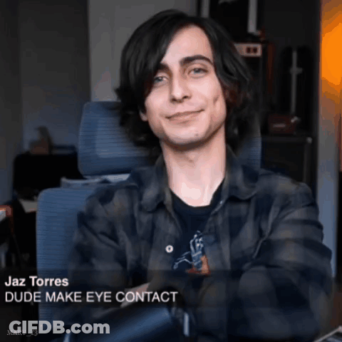 A Young Man In A Plaid Shirt Is Sitting In A Chair And Smiling With The Caption " Dude Make Eye Contact " GIF