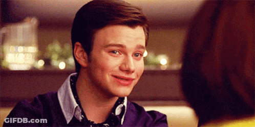 A Young Man In A Purple Sweater Is Smiling GIF