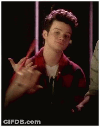 A Young Man In A Red And Black Plaid Shirt Is Making A Funny Face . GIF