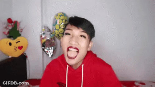 A Young Man In A Red Hoodie Sticks Out His Tongue GIF
