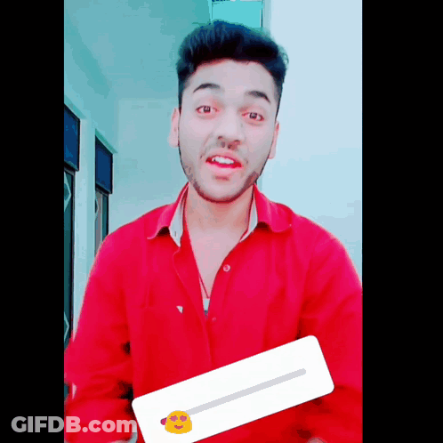 A Young Man In A Red Shirt Is Holding A Sticker With A Yellow Face On It GIF