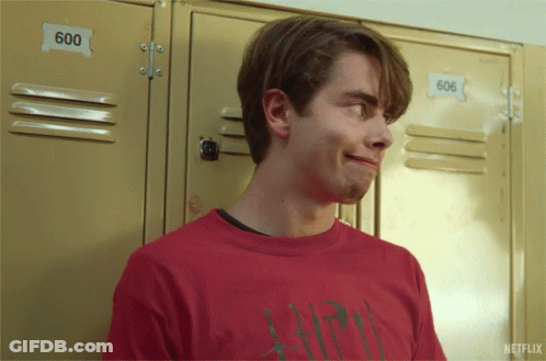 A Young Man In A Red Shirt Is Standing In Front Of Lockers With The Number 600 On Them GIF