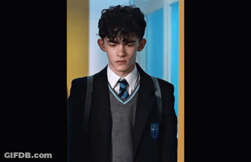A Young Man In A School Uniform With The Letter T On His Jacket . GIF