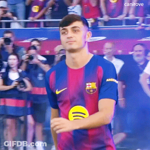 A Young Man In A Soccer Jersey Is Standing In Front Of A Crowd . GIF