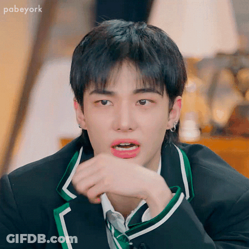 A Young Man In A Suit And Tie Is Making A Funny Face GIF