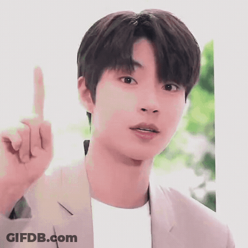 A Young Man In A Suit Is Pointing His Finger Up . GIF