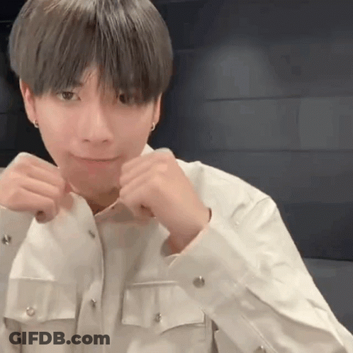 A Young Man In A White Shirt Is Making A Funny Face With His Hands In The Air . GIF