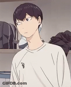 A Young Man In A White Shirt Is Standing In A Room . GIF