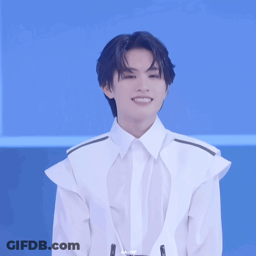 A Young Man In A White Shirt With Aa Written On The Bottom Right GIF