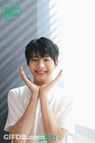 A Young Man In A White Shirt With The Name Golden Child On The Bottom Right GIF