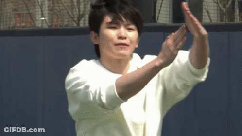 A Young Man In A White Sweater Is Clapping His Hands . GIF