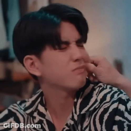 A Young Man In A Zebra Print Shirt Is Covering His Nose With His Hand . GIF