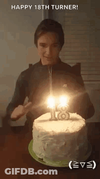 A Young Man Is Blowing Out The Candles On His 18Th Birthday Cake . GIF