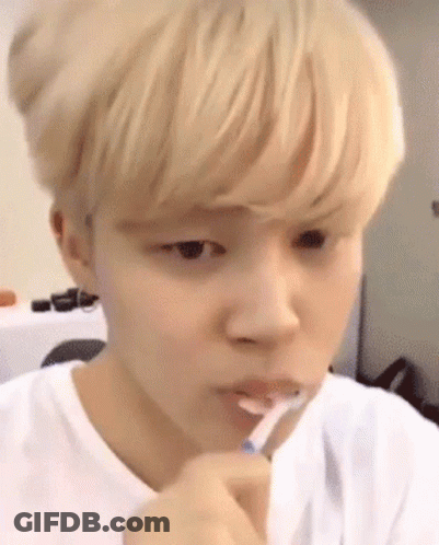 A Young Man Is Brushing His Teeth With A Toothbrush GIF