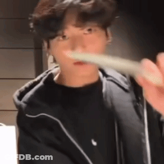 A Young Man Is Brushing His Teeth With A Toothbrush While Wearing A Black Jacket . GIF
