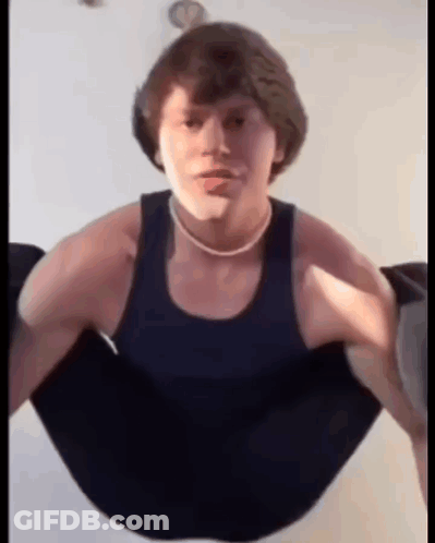 A Young Man Is Doing Push Ups In A Black Tank Top And A Necklace . GIF
