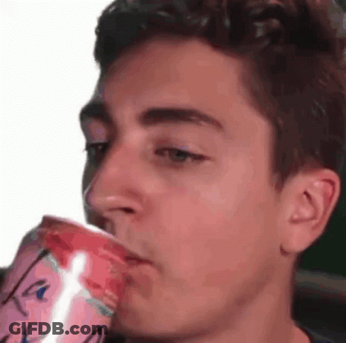 A Young Man Is Drinking A Can Of Soda From A Cup . GIF