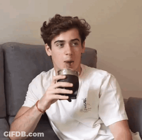 A Young Man Is Drinking From A Cup That Says The Valley Club GIF