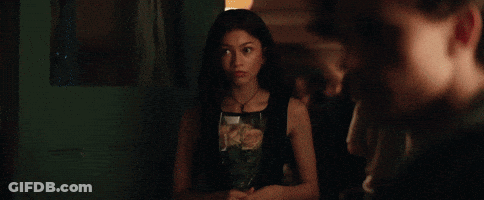 A Young Man Is Drinking From A Red Cup In A Room . GIF