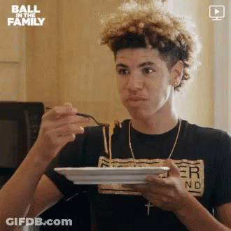 A Young Man Is Eating Spaghetti With A Spoon From A Plate . GIF