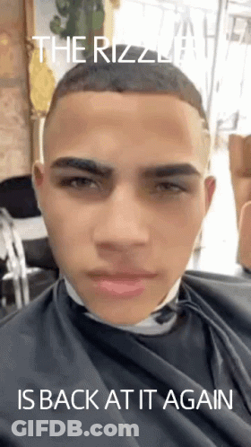 A Young Man Is Getting His Hair Cut At A Barber Shop With The Caption " The Rizzla Is Back At It Again " GIF
