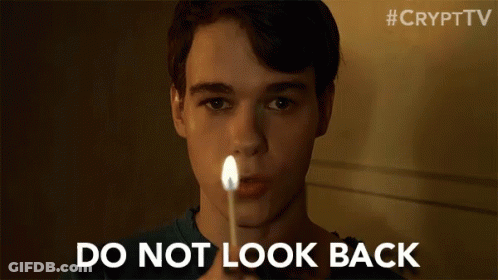 A Young Man Is Holding A Lit Match In Front Of His Face And Says `` Do Not Look Back '' . GIF