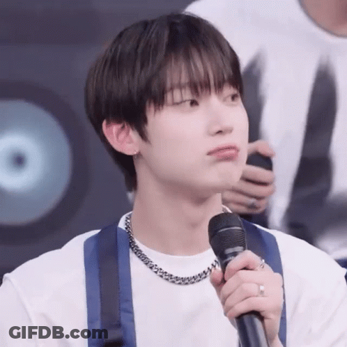A Young Man Is Holding A Microphone In His Hand . GIF