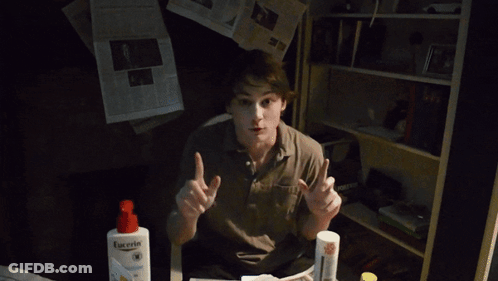 A Young Man Is Holding A Newspaper That Says The New York Journal On It GIF
