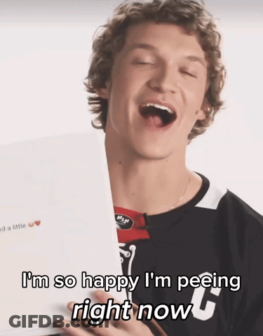 A Young Man Is Holding A Piece Of Paper With The Words I 'M So Happy I 'M Peeing Right Now On It GIF