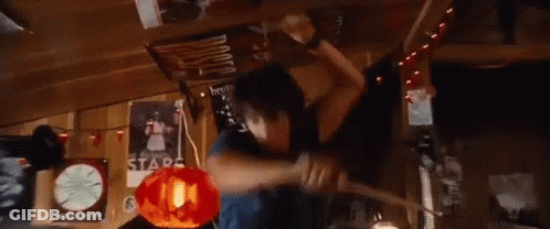 A Young Man Is Holding A Piece Of Wood In His Hands And Making A Funny Face . GIF