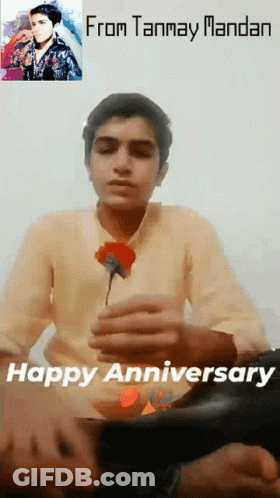 A Young Man Is Holding A Red Rose In Front Of A Picture Of A Man And The Words From Tanmay Mandan Happy Anniversary GIF