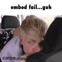 A Young Man Is Laying In The Back Seat Of A Car With His Head On The Back Seat Cushion . GIF
