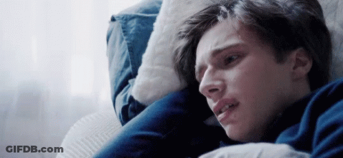 A Young Man Is Laying On A Couch With His Head On A Pillow . GIF