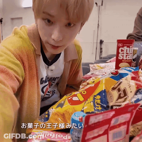 A Young Man Is Looking At A Bag Of Chips That Says Chi Star On It GIF