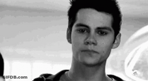 A Young Man Is Looking At The Camera In A Black And White Photo . GIF