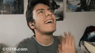 A Young Man Is Making A Funny Face And Clapping His Hands . GIF