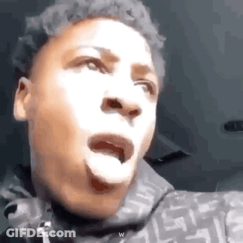 A Young Man Is Making A Funny Face In A Car . GIF