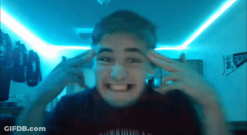 A Young Man Is Making A Funny Face In Front Of A Blue Light GIF