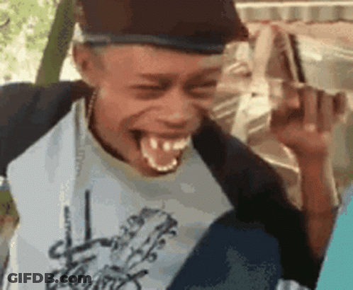 A Young Man Is Making A Funny Face While Wearing A Hat . GIF