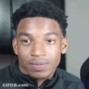 A Young Man Is Making A Funny Face While Wearing A Jacket . GIF