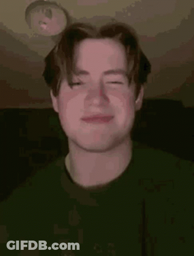 A Young Man Is Making A Funny Face With His Eyes Closed . GIF