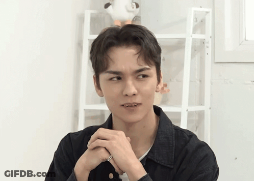 A Young Man Is Making A Funny Face With His Hands Folded GIF