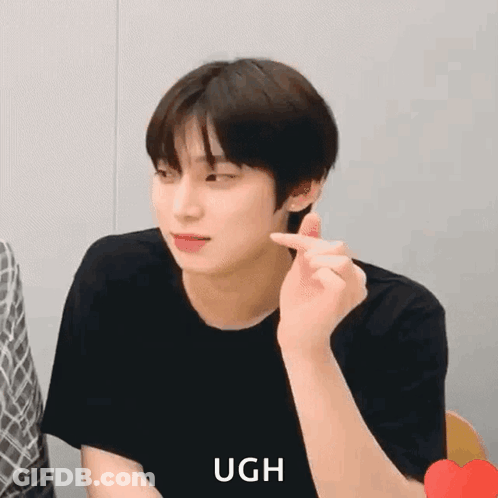 A Young Man Is Making A Heart Shape With His Finger While Wearing A Black Shirt . GIF