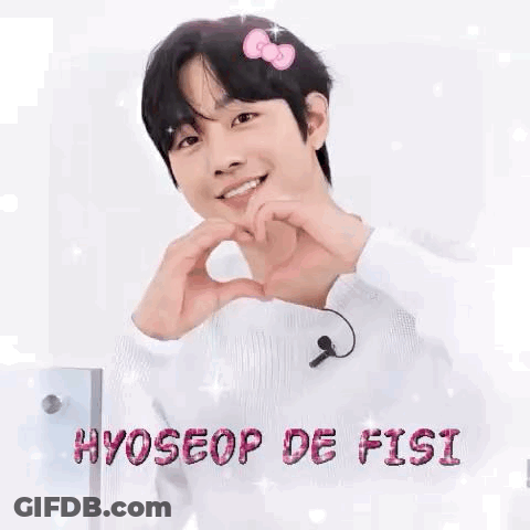 A Young Man Is Making A Heart Shape With His Hands While Wearing A Hello Kitty Headband . GIF