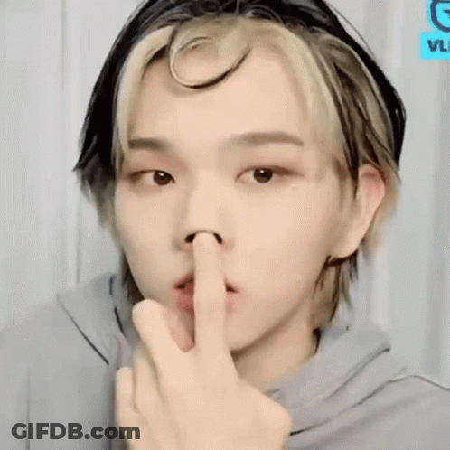 A Young Man Is Making A Shhh Sign With His Finger In His Mouth . GIF