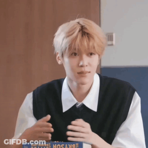 A Young Man Is Sitting At A Table With A Box Of Skyson GIF